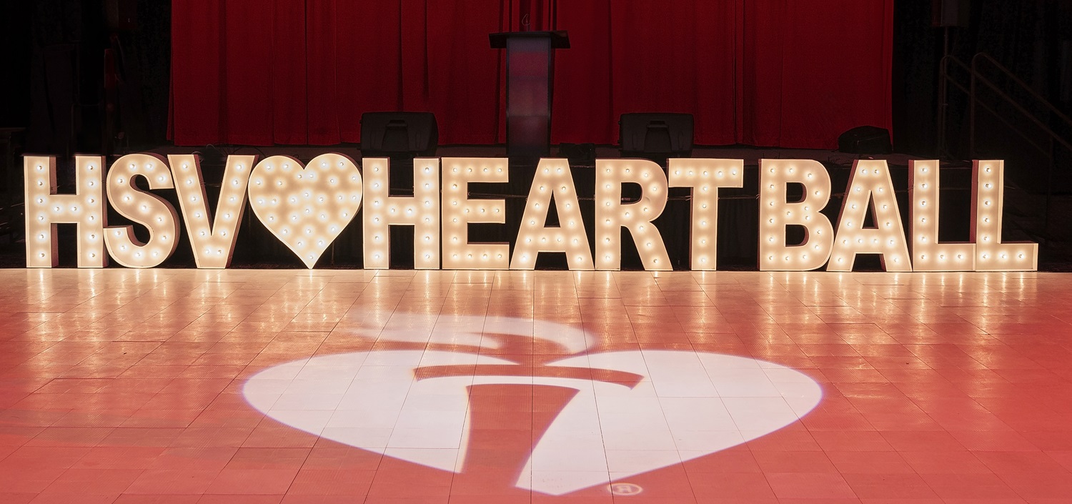 Large letters spelling out H S V Heart Ball with Heart and Torch Projection in front.